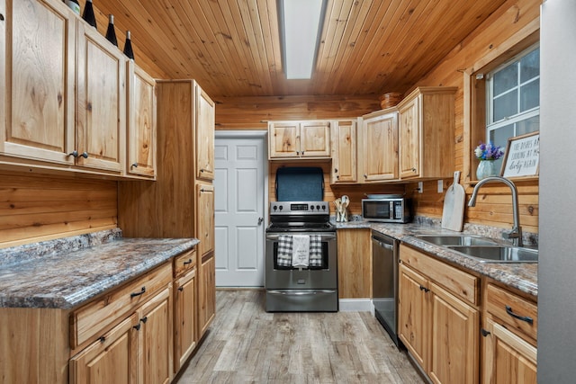 kitchen featuring appliances with stainless steel finishes, light wood-type flooring, stone countertops, and sink