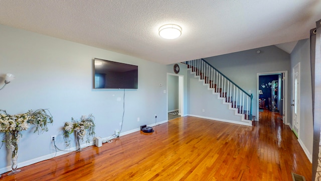 unfurnished living room with wood-type flooring and a textured ceiling