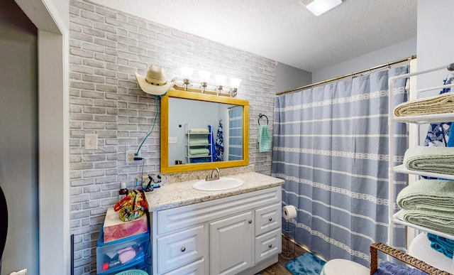 bathroom featuring brick wall, wood-type flooring, a textured ceiling, vanity, and a shower with shower curtain