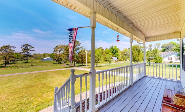 deck featuring covered porch and a lawn