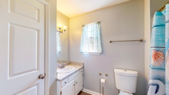 bathroom featuring a textured ceiling, vanity, and toilet