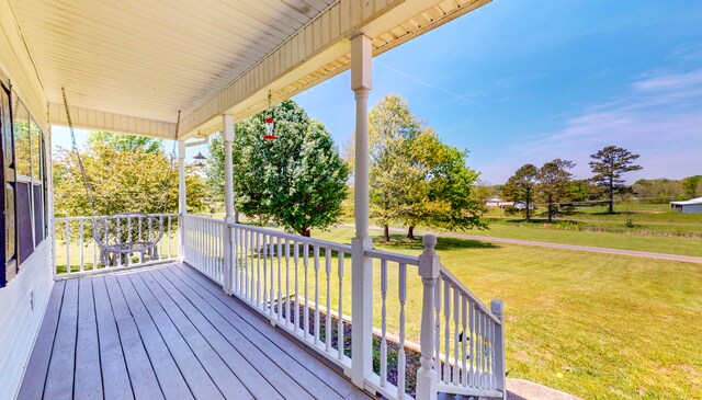 wooden deck with a lawn and a porch