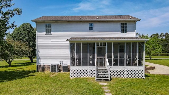 back of property featuring a sunroom, central AC unit, and a lawn