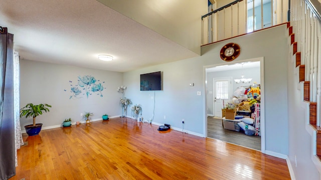 interior space featuring hardwood / wood-style floors, a textured ceiling, and a chandelier