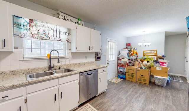 kitchen featuring white cabinetry, sink, hanging light fixtures, stainless steel dishwasher, and hardwood / wood-style floors