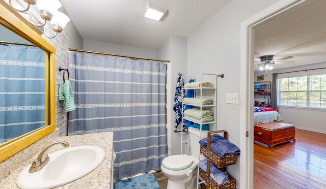 bathroom with hardwood / wood-style floors, vanity, a textured ceiling, and toilet