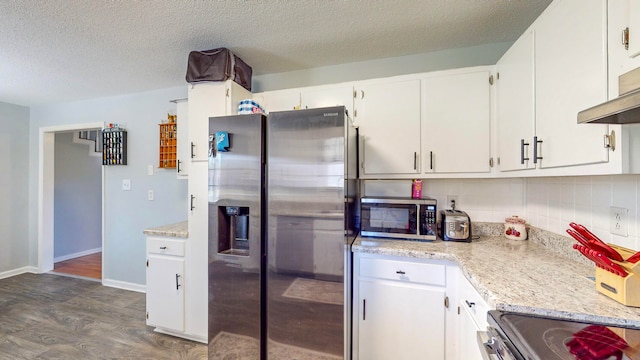 kitchen with tasteful backsplash, stainless steel appliances, white cabinetry, and dark hardwood / wood-style floors