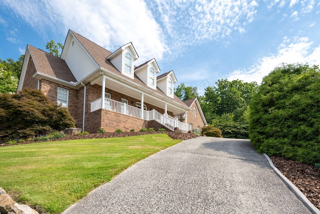 view of side of home featuring a yard and covered porch