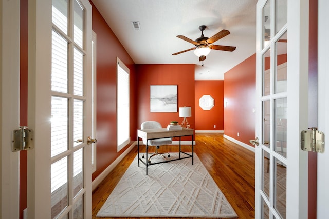 office area featuring french doors, hardwood / wood-style flooring, ceiling fan, and a healthy amount of sunlight