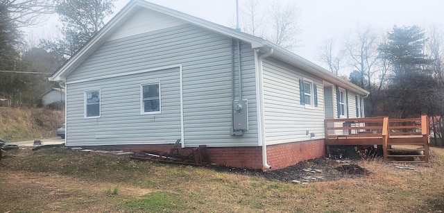 view of home's exterior featuring a lawn and a deck