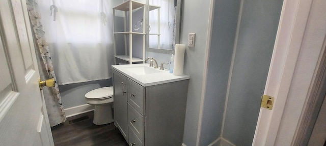 bathroom with wood-type flooring, vanity, a shower with shower curtain, and toilet