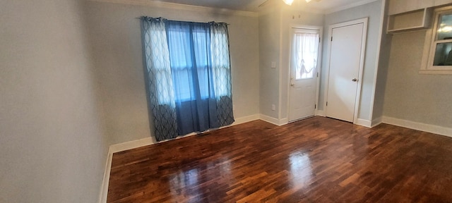 unfurnished room with a wealth of natural light, crown molding, and dark hardwood / wood-style flooring