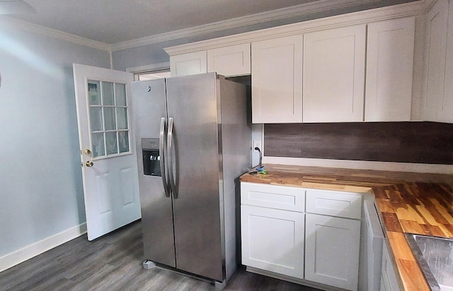 kitchen featuring butcher block counters, dark wood-type flooring, stainless steel refrigerator with ice dispenser, ornamental molding, and white cabinetry