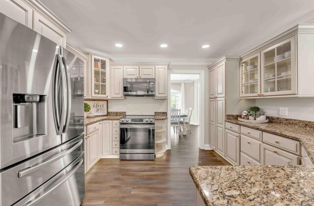1732 Brookwood Dr NE, Cleveland, TN 37323 - kitchen with glass insert cabinets, wood finished floors, crown molding, appliances with stainless steel finishes, and light stone counters