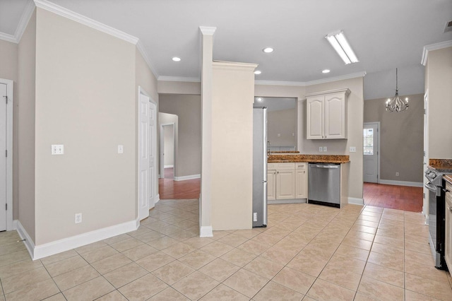 kitchen with light tile patterned floors, a chandelier, stainless steel appliances, and ornamental molding