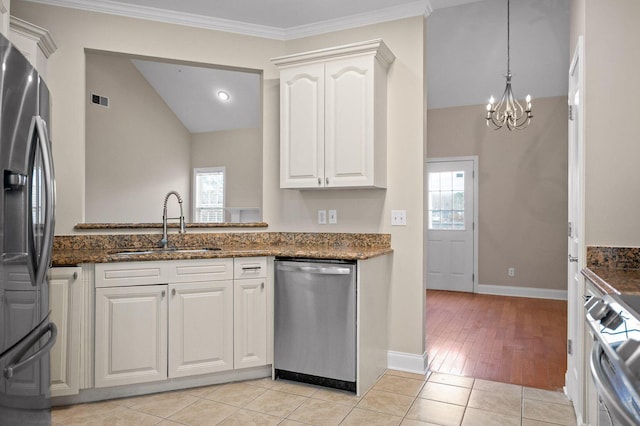 kitchen featuring appliances with stainless steel finishes, plenty of natural light, a sink, and light tile patterned floors