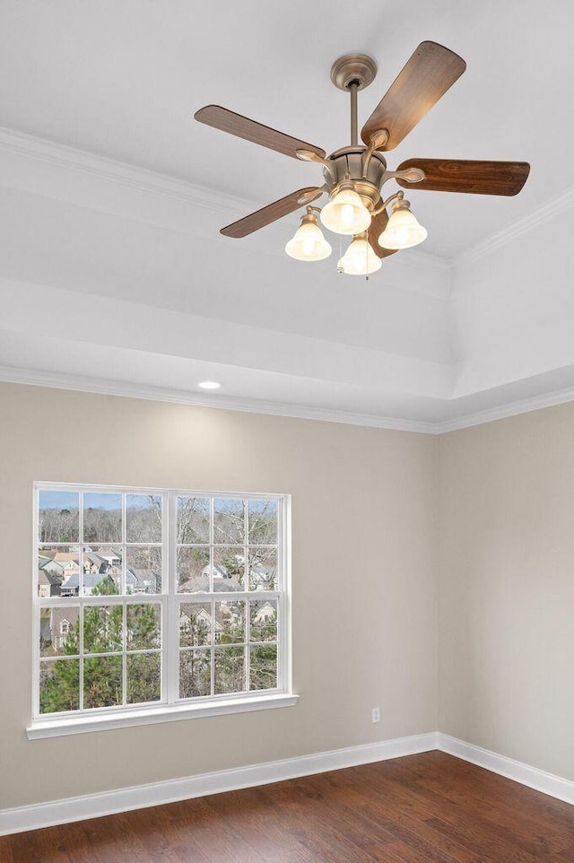 unfurnished room featuring crown molding, dark wood finished floors, baseboards, and ceiling fan