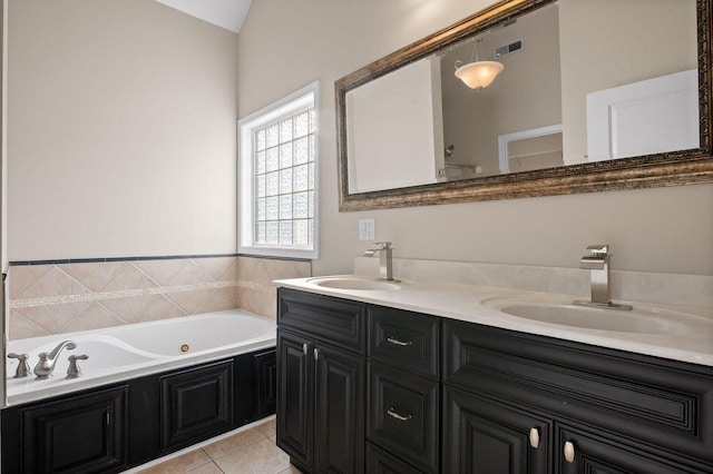 full bath featuring double vanity, a sink, a tub with jets, and tile patterned floors