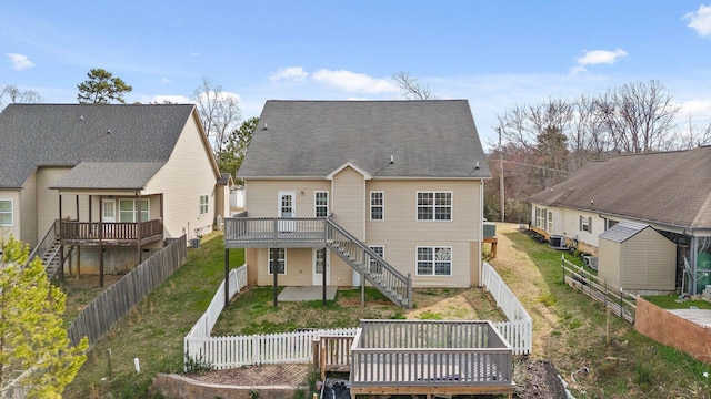 back of property featuring a fenced backyard, stairs, a lawn, and a wooden deck