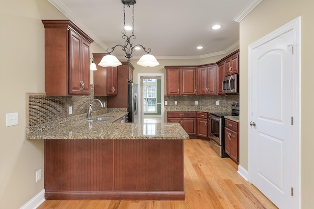 kitchen with a sink, light stone counters, light wood finished floors, a peninsula, and stainless steel appliances