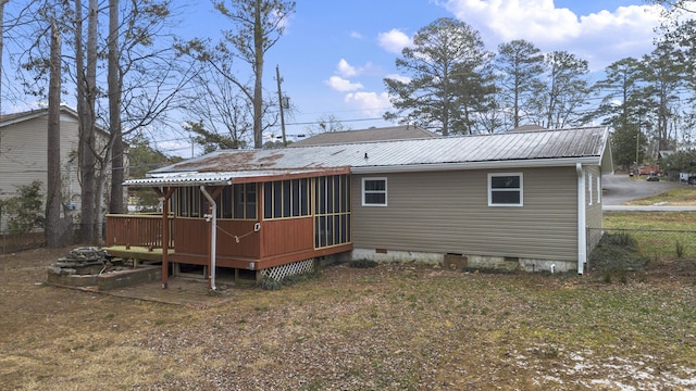 rear view of house with a wooden deck and a sunroom