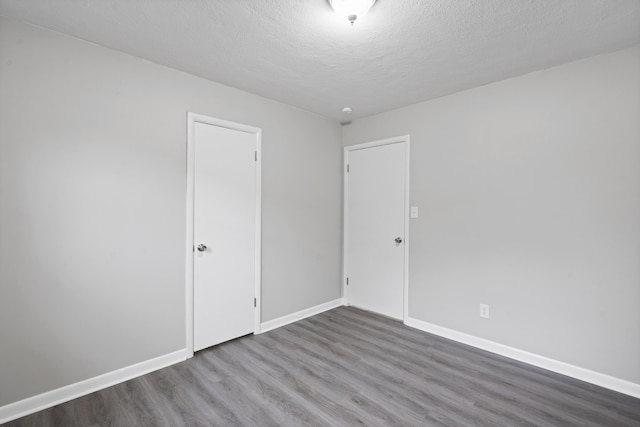 spare room with wood-type flooring and a textured ceiling