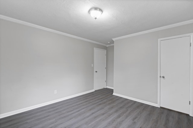 spare room featuring crown molding, dark wood-type flooring, and a textured ceiling