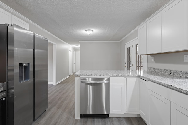 kitchen featuring white cabinetry, stainless steel appliances, and kitchen peninsula