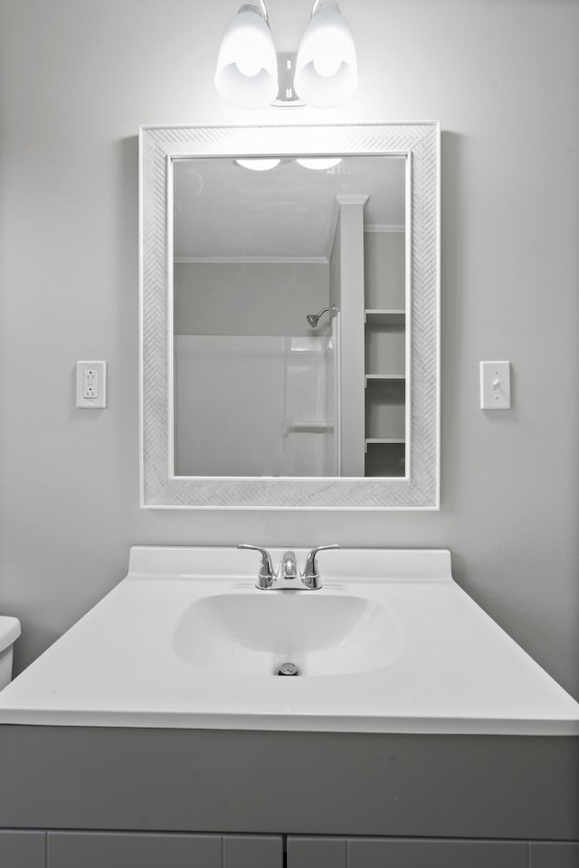 bathroom with vanity, a shower, and toilet