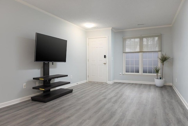 unfurnished living room featuring baseboards, ornamental molding, and wood finished floors