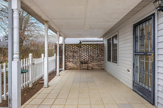 view of patio featuring covered porch and fence