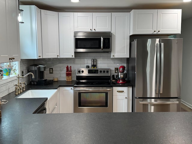 kitchen featuring white cabinets, sink, stainless steel appliances, and tasteful backsplash