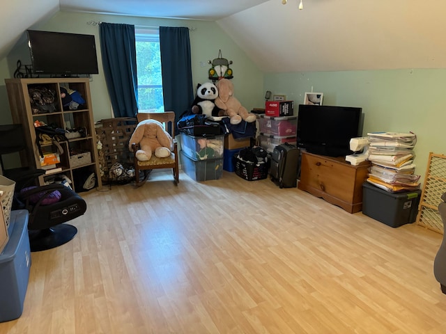 additional living space with light hardwood / wood-style flooring and vaulted ceiling