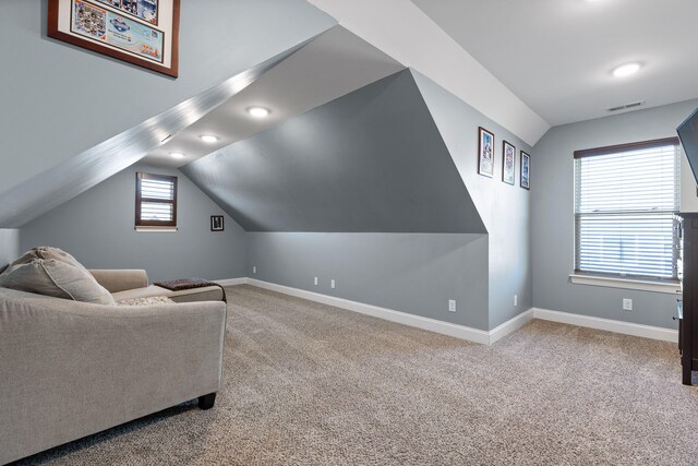 sitting room featuring carpet flooring and vaulted ceiling