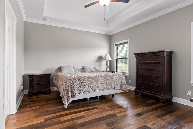 bedroom featuring a raised ceiling, ceiling fan, crown molding, and dark wood-type flooring