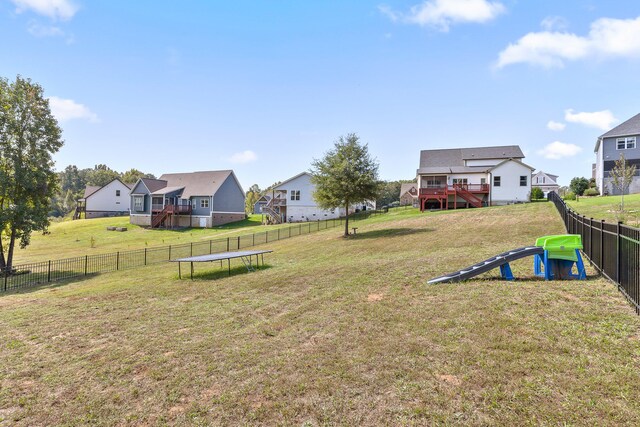 view of yard with a wooden deck and a trampoline