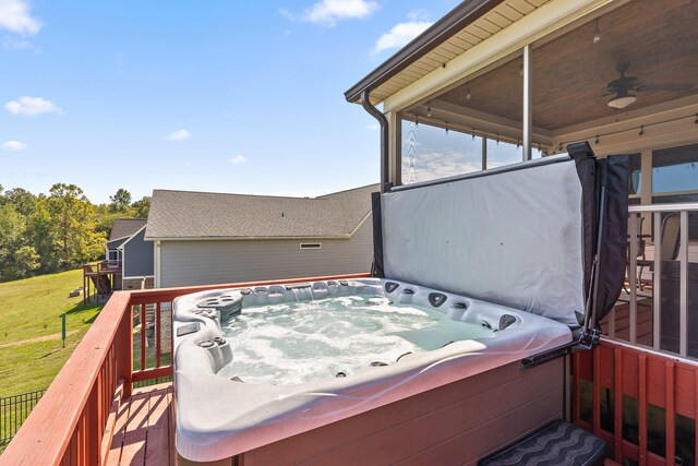 deck with ceiling fan, a yard, and a hot tub