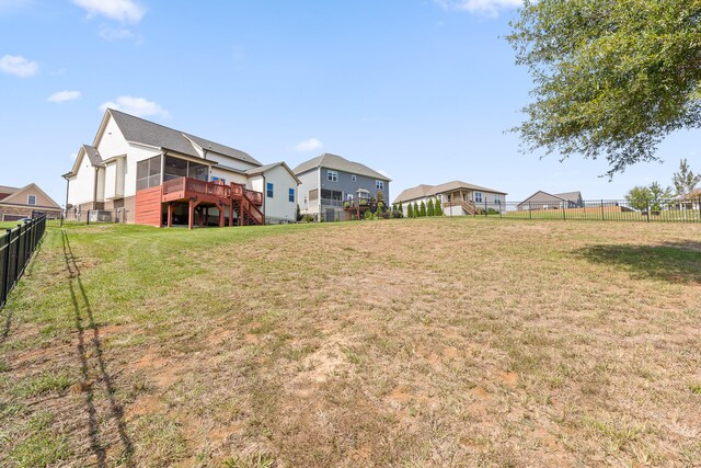 view of yard featuring a sunroom and a wooden deck