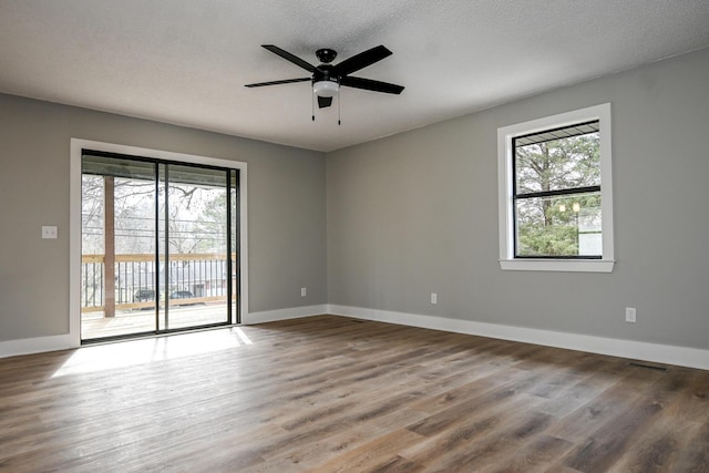 unfurnished room featuring ceiling fan, hardwood / wood-style floors, and a textured ceiling