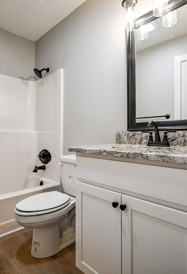 full bathroom with vanity, hardwood / wood-style floors, shower / bathtub combination, and toilet