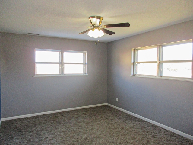 carpeted empty room with ceiling fan and plenty of natural light