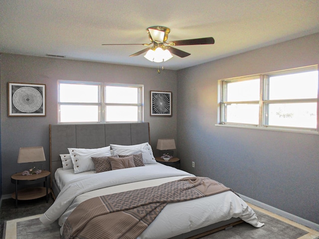 bedroom featuring multiple windows and ceiling fan