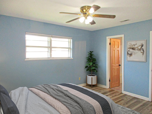 bedroom with wood-type flooring and ceiling fan