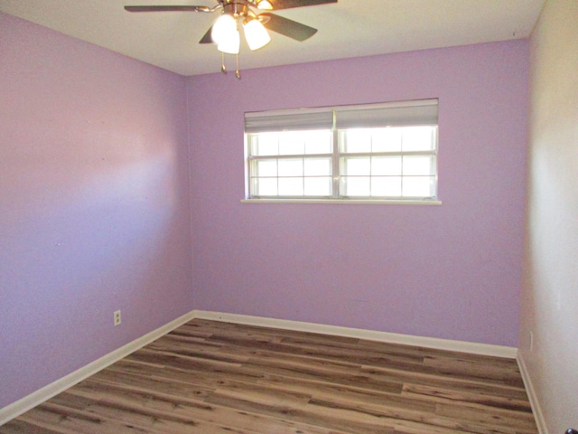 unfurnished room featuring dark wood-type flooring and ceiling fan