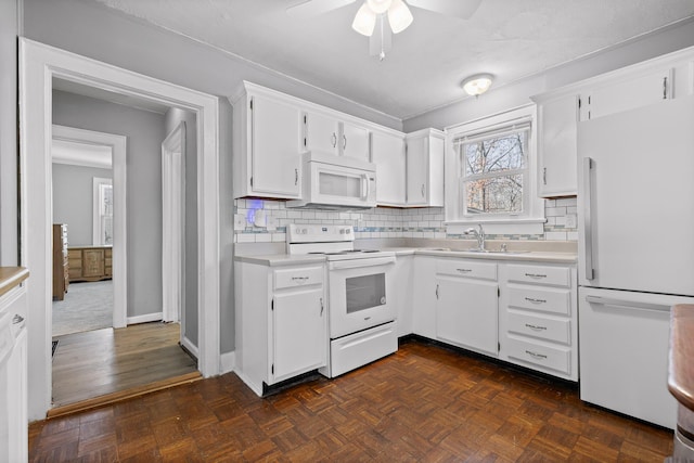 kitchen with white cabinetry, sink, white appliances, and dark parquet flooring