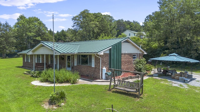 7209 Anthem Trl, Birchwood, TN 37308 - view of front of property with a standing seam roof, brick siding, a front yard, a metal roof, and a patio area