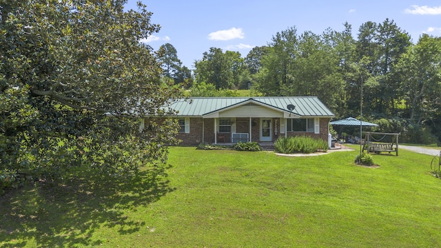 7209 Anthem Trl, Birchwood, TN 37308 - view of front of home featuring covered porch, a front yard, brick siding, a standing seam roof, and a metal roof