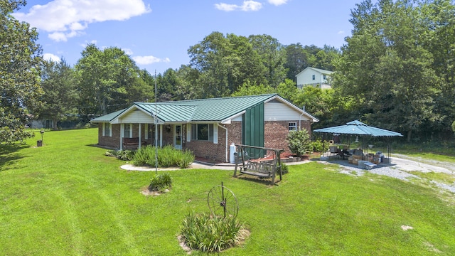7209 Anthem Trl, Birchwood, TN 37308 - view of front of house with brick siding, a front yard, a patio, a standing seam roof, and a metal roof