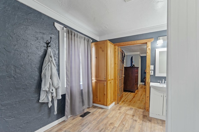 bathroom featuring hardwood / wood-style floors, vanity, and crown molding