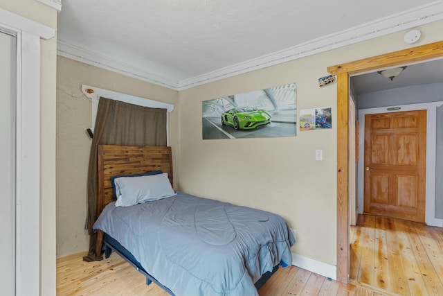 bedroom featuring hardwood / wood-style floors and ornamental molding